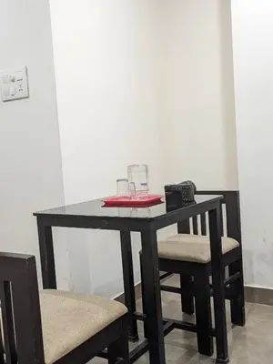 a black table with two chairs and a glass at Raaha Residency in Kozhikode