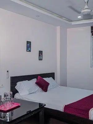 a bedroom with two beds and a table with wine glasses at Raaha Residency in Kozhikode