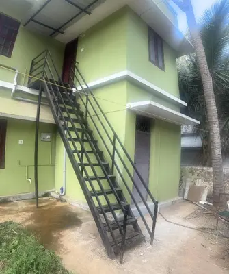 a stairway leading up to a green house at Lilly in Alattūr