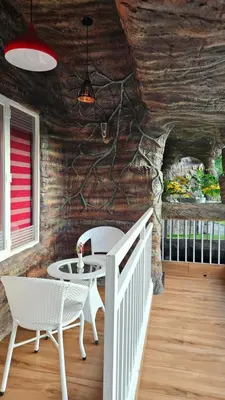 a room with a table and chairs and a stone wall at S & B Dreams House in Munnar