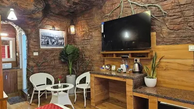 a bar with a tv on a stone wall at S & B Dreams House in Munnar