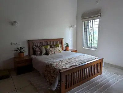 a bedroom with a large bed in a room with a window at Red Rock Villa, Virajpet, Coorg in Virajpet