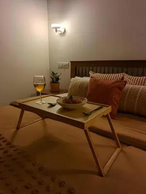 a table with a bowl of food and a glass of wine at Red Rock Villa, Virajpet, Coorg in Virajpet