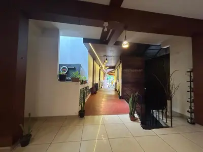 a hallway in a building with plants on the walls at RIO ROOMS Medical College in Kozhikode