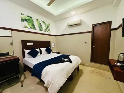 a hotel room with a bed and a television at RIO ROOMS Medical College in Kozhikode