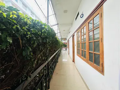 a corridor of a greenhouse with plants at RIO ROOMS Medical College in Kozhikode