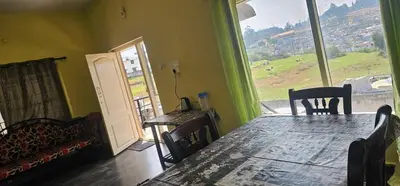 a living room with a couch and a table and a window at OOTY STAY AWHILE in Ooty