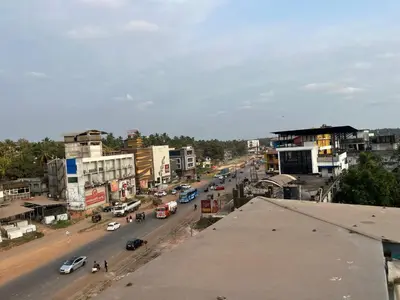 a view of a city street with cars and buildings at Plaza Residency in Badagara