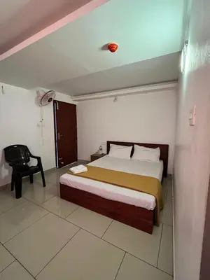 a hotel room with a bed and a chair at Plaza Residency in Badagara