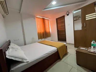 a small bedroom with a bed and a window at Plaza Residency in Badagara