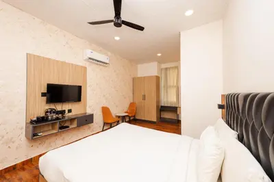 a bedroom with a bed and a flat screen tv at THE CONTINENTAL INN & SUITES in Mysore