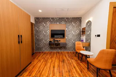 a room with a tv and a table and chairs at THE CONTINENTAL INN & SUITES in Mysore