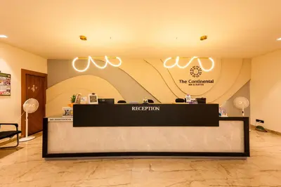 a reception desk in a lobby with a sign at THE CONTINENTAL INN & SUITES in Mysore