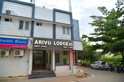 a building with an amu lodgers sign in front of it at ARIVU LODGE AC in Anaimalai