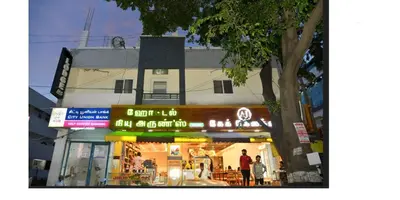 a store with neon signs in front of a building at ARIVU LODGE AC in Anaimalai