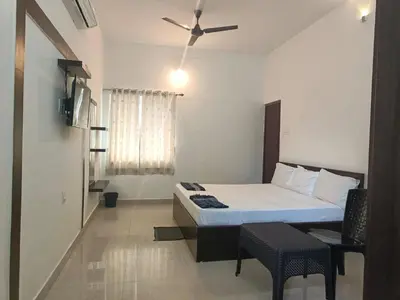 a bedroom with a bed and a ceiling fan at ARIVU LODGE AC in Anaimalai