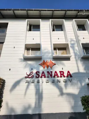a building with a sign on the side of it at Le Sanara Residency in Thanniyam