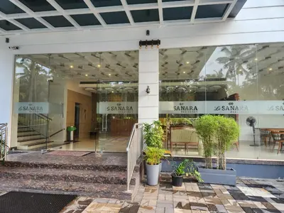 a building with glass doors and potted plants in front at Le Sanara Residency in Thanniyam