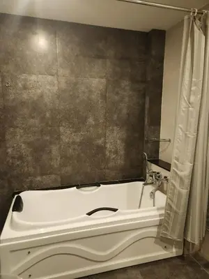 a white bath tub in a bathroom with a shower at Le Sanara Residency in Thanniyam