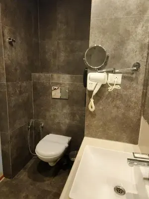 a bathroom with a toilet and a sink at Le Sanara Residency in Thanniyam