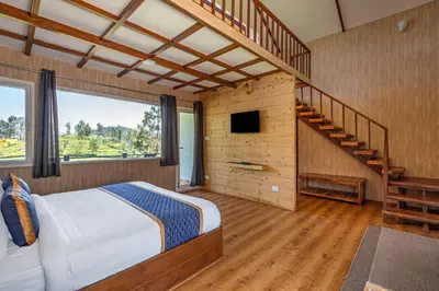 a bedroom with a large bed and a staircase at Wattle Grove Resort in Kotagiri