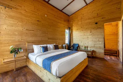 a bedroom with a bed in a wooden room at Wattle Grove Resort in Kotagiri
