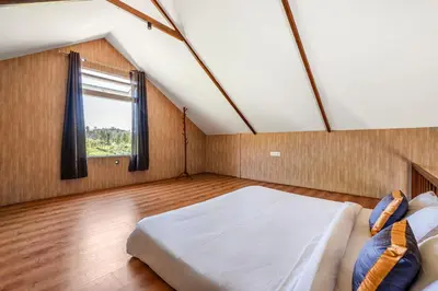 a bedroom with a large bed and a window at Wattle Grove Resort in Kotagiri