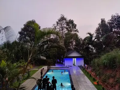 a group of people standing around a swimming pool at Verdant Hillock in Wayanad
