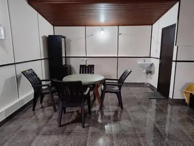 a dining room with a table and chairs and a sink at Verdant Hillock in Wayanad