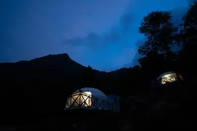 two domes are lit up at night at Nexstay Karimb Resorts in Vallikavungal
