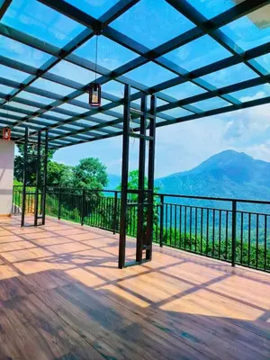 a screened porch with a view of the mountains at Nexstay Karimb Resorts in Vallikavungal