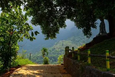 a dirt road with a statue on the side of a hill at Nexstay Karimb Resorts in Vallikavungal