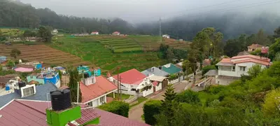 an aerial view of a village with houses and ricefields at Fortune Retreats in Ooty