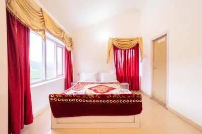 a bedroom with a bed with red curtains and a window at Fortune Retreats in Ooty