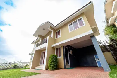 a house with a garage in front of it at Fortune Retreats in Ooty
