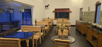 a row of tables and chairs in a restaurant at Fortune Retreats in Ooty
