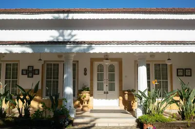 a house with a front porch with plants at Marlihill Bungalow - A CGH Earth SAHA Experience in Ooty