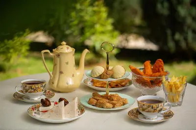 a table with plates of food and cups of coffee at Marlihill Bungalow - A CGH Earth SAHA Experience in Ooty