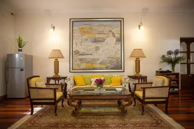 a living room with a couch and two chairs at Marlihill Bungalow - A CGH Earth SAHA Experience in Ooty