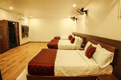 a hotel room with two beds and a television at GREEN MOUNT RESORTS in Malaiyāndipattanam