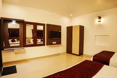 a hotel room with two beds and a television at GREEN MOUNT RESORTS in Malaiyāndipattanam