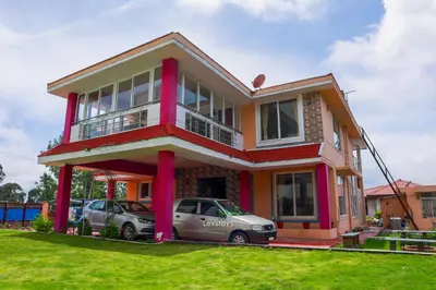 a house with two cars parked in front of it at Green Premium Villa Ooty by Lexstays in Ooty