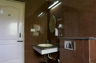 a bathroom with a sink and a mirror at Green Premium Villa Ooty by Lexstays in Ooty