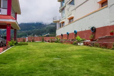 a green lawn in front of a building at Green Premium Villa Ooty by Lexstays in Ooty