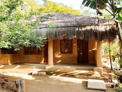 a small house with a thatched roof at Cosmic Mud House Kanthalloor in Kanthalloor
