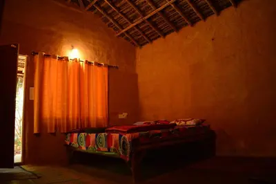 a bedroom with a bed with an orange curtain at Cosmic Mud House Kanthalloor in Kanthalloor