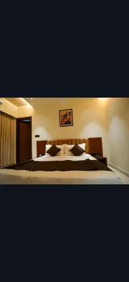 a bedroom with a large bed with white sheets and pillows at Hotel Harigovindas Express Mysore in Mysore