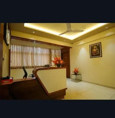 a living room with a couch and a ceiling fan at Hotel Harigovindas Express Mysore in Mysore