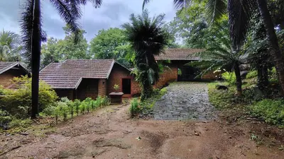 a brick house with a pathway next to a building at Shantam Homestay - Powered by Grackle in Cheruthuruthi