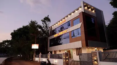 a building with a sign on the side of it at Manu's Home Stay in Malayāttūr